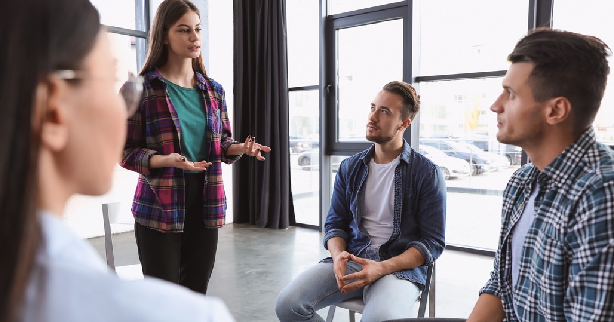 Girl standing up and sharing during group therapy session